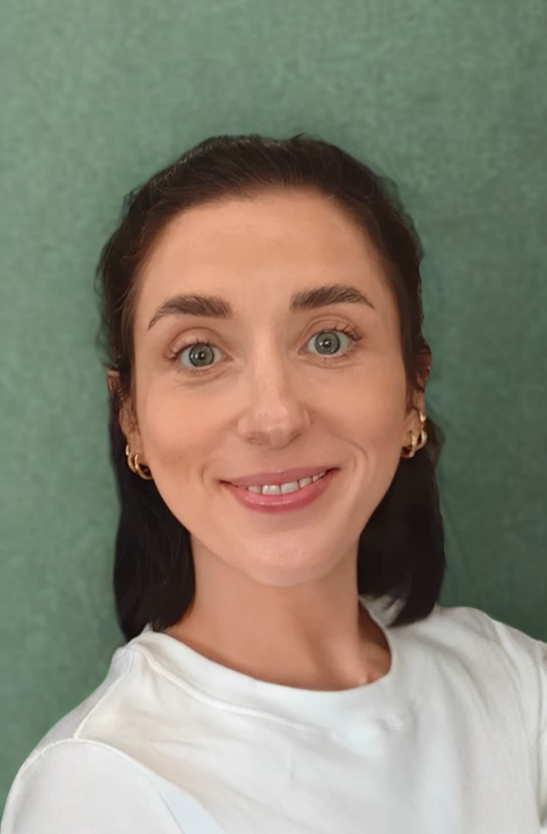 Rebecca Bromley smiling, in front of a green wall